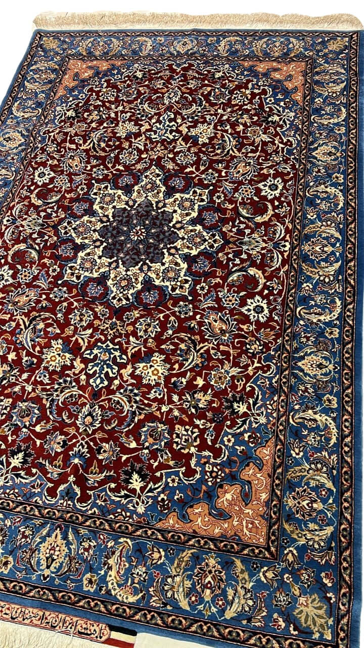 "Close-up of a Seirafian Isfahan rug with floral design, showing detailed hand-knotted craftsmanship in silk and wool."